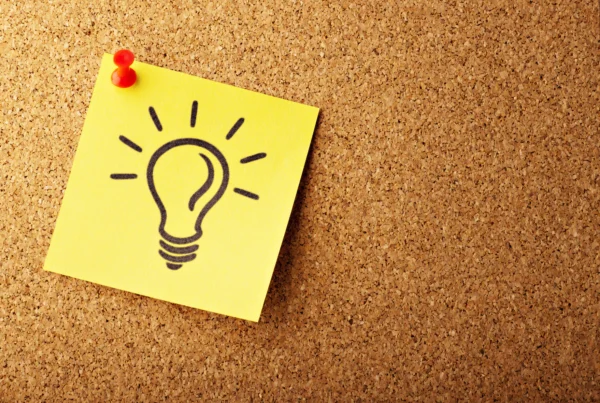a sticky note with a drawing of a light bulb, expressing an idea.