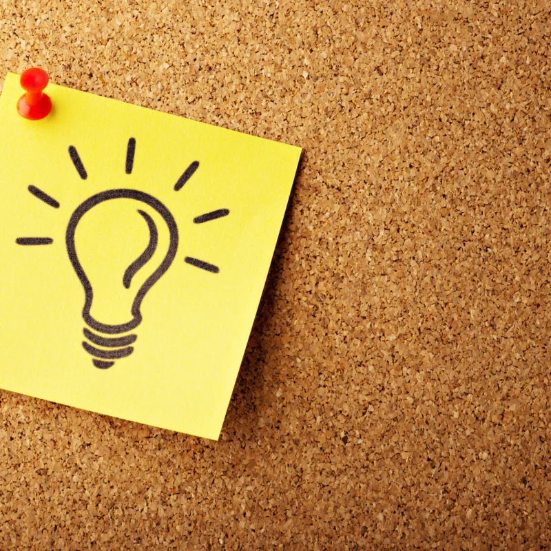a sticky note with a drawing of a light bulb, expressing an idea.